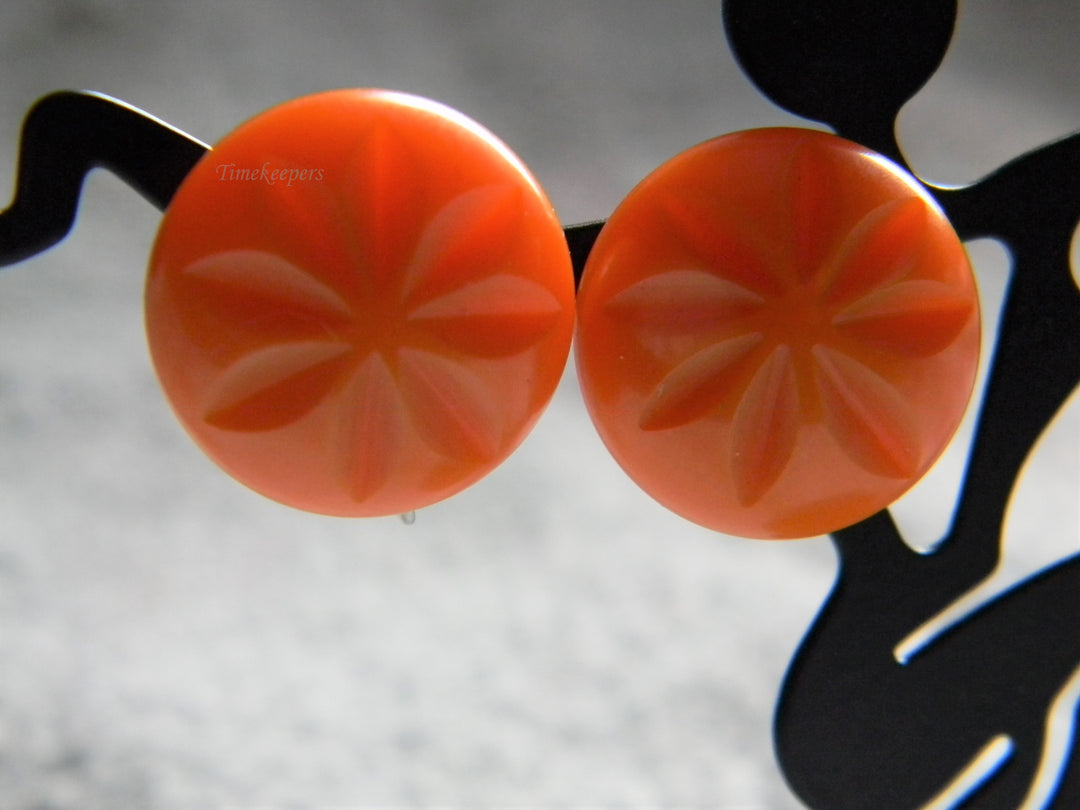j928 Beautiful Vintage Orange Bakelite Clip Earrings with Flower Impression