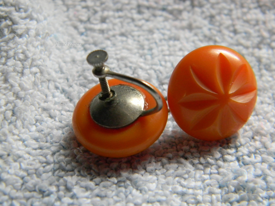 j928 Beautiful Vintage Orange Bakelite Clip Earrings with Flower Impression