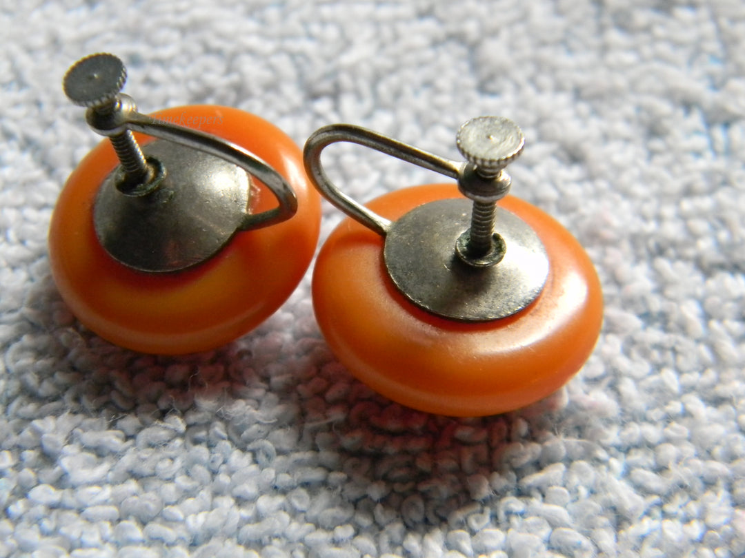 j928 Beautiful Vintage Orange Bakelite Clip Earrings with Flower Impression