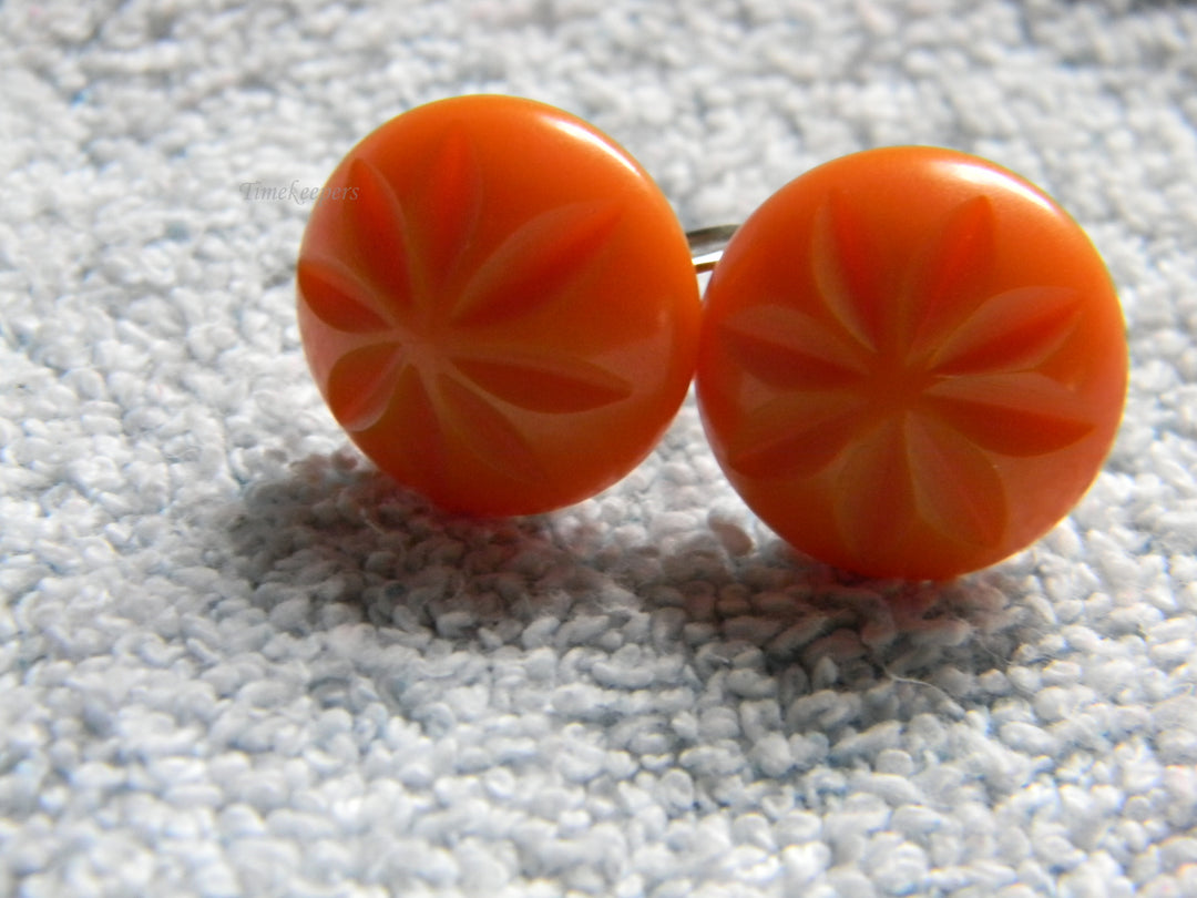 j928 Beautiful Vintage Orange Bakelite Clip Earrings with Flower Impression